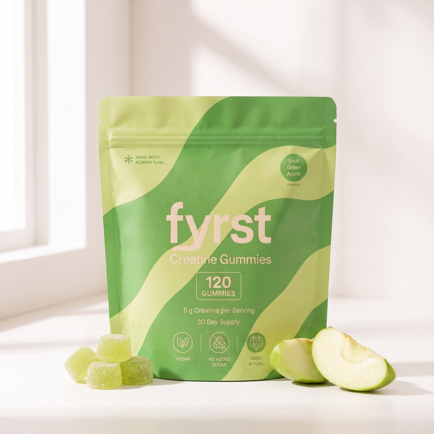 fyrst Sour Green Apple Creatine Gummies – Beutel mit Gummies und Apfelspalten auf heller Fensterbank